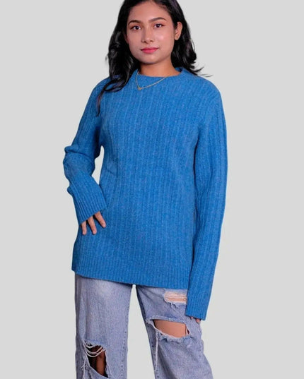 Cashmere cable pullover worn by woman in blue sweater and ripped jeans