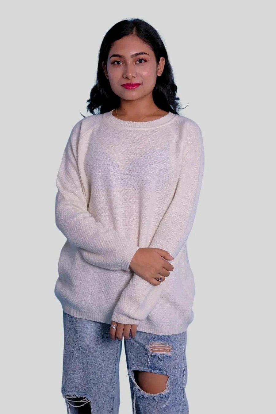 Woman wearing white sweater and ripped jeans - KCI 303 women crew neck pullover