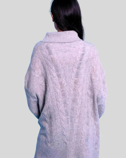 Woman wearing luxurious cashmere oversized cable pullover in grey sweater and jeans