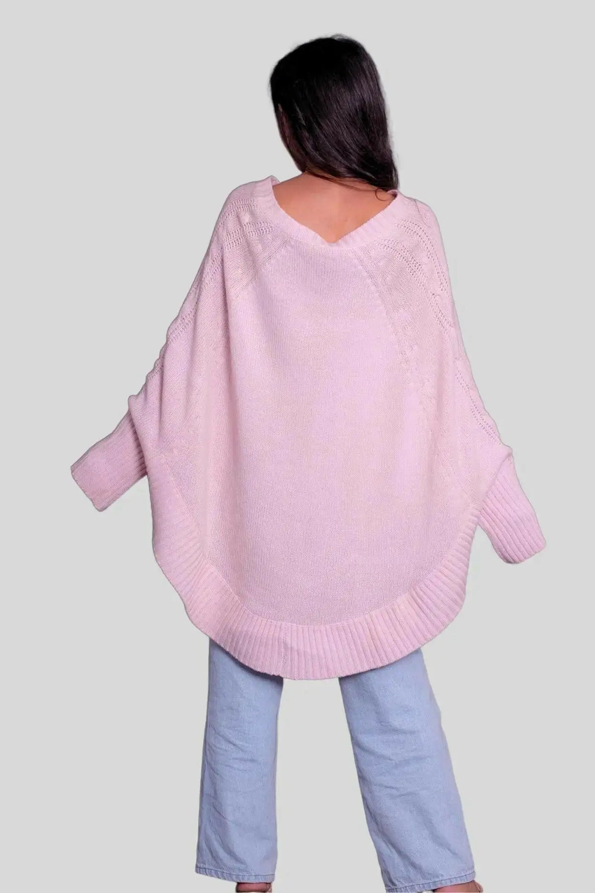 Woman styling a pink Italian cashmere poncho with jeans
