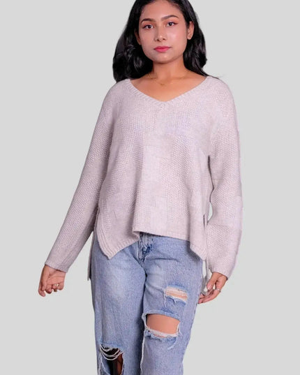 Woman in luxurious Italian cashmere pullover with ripped jeans