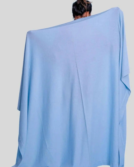 Woman wearing blue poncho with luxurious Italian cashmere throw blanket