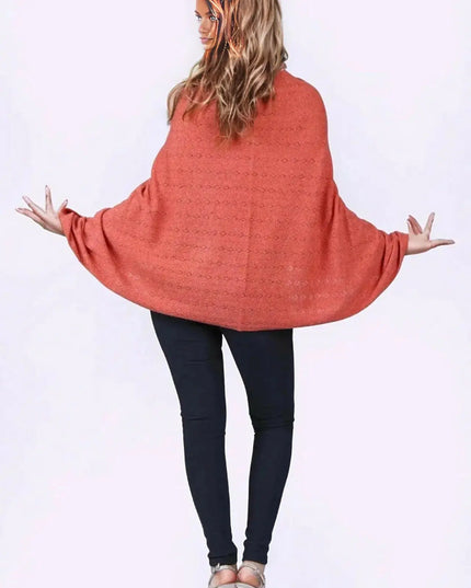 KCI 120 cashmere poncho with woman in red sweater and black pants standing with arms out