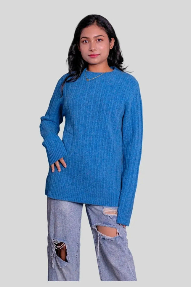 Cashmere cable pullover worn by woman in blue sweater and ripped jeans