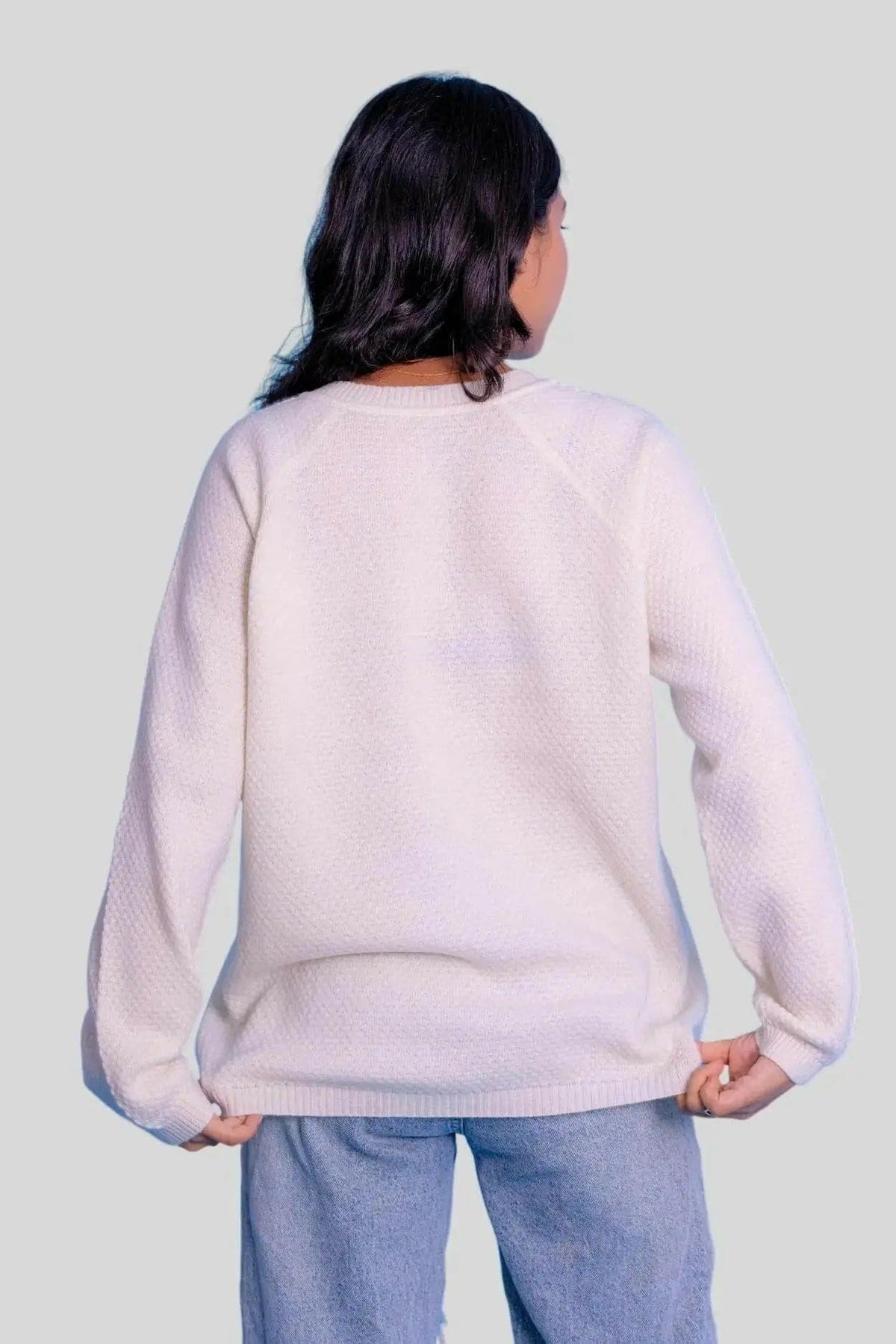 Stylish woman in white crew neck pullover and jeans from KCI 303 collection