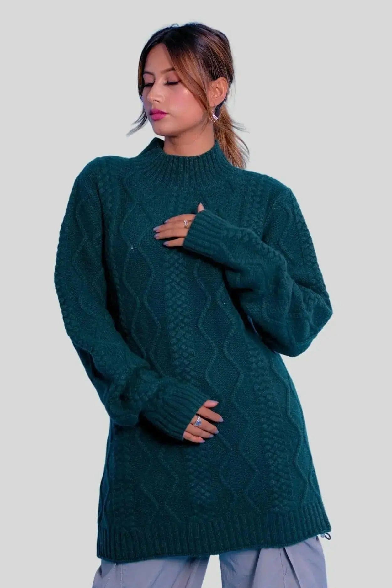 Stylish woman in green sweater and grey pants, showcasing Luxurious Cashmere Cable Dress