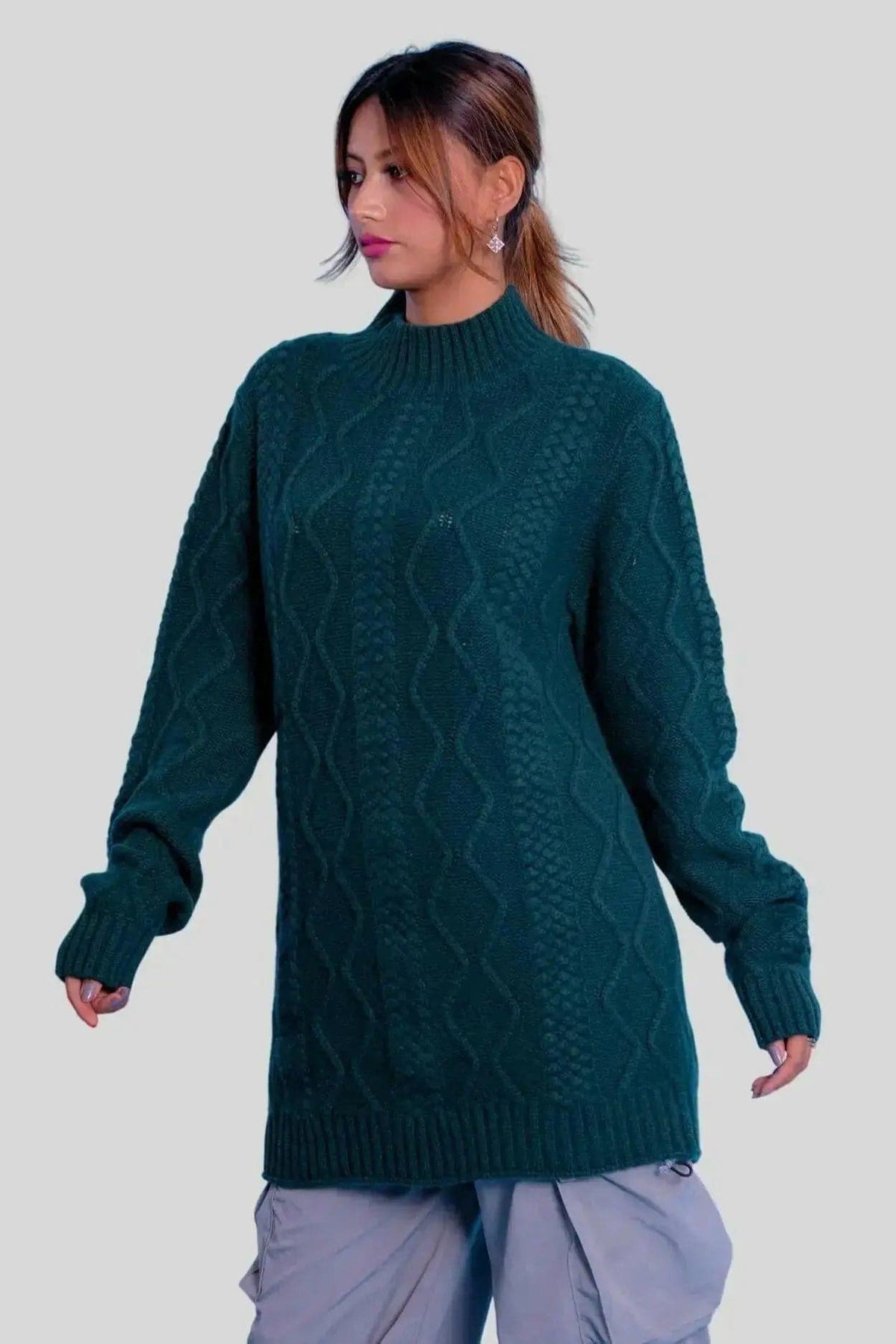 Woman in green sweater and grey pants modeling Luxurious Cashmere Cable Dress