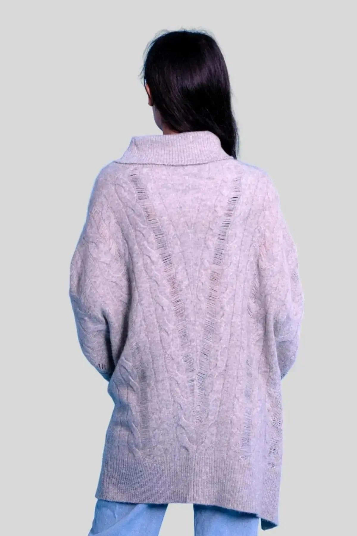 Woman wearing luxurious cashmere oversized cable pullover in grey sweater and jeans