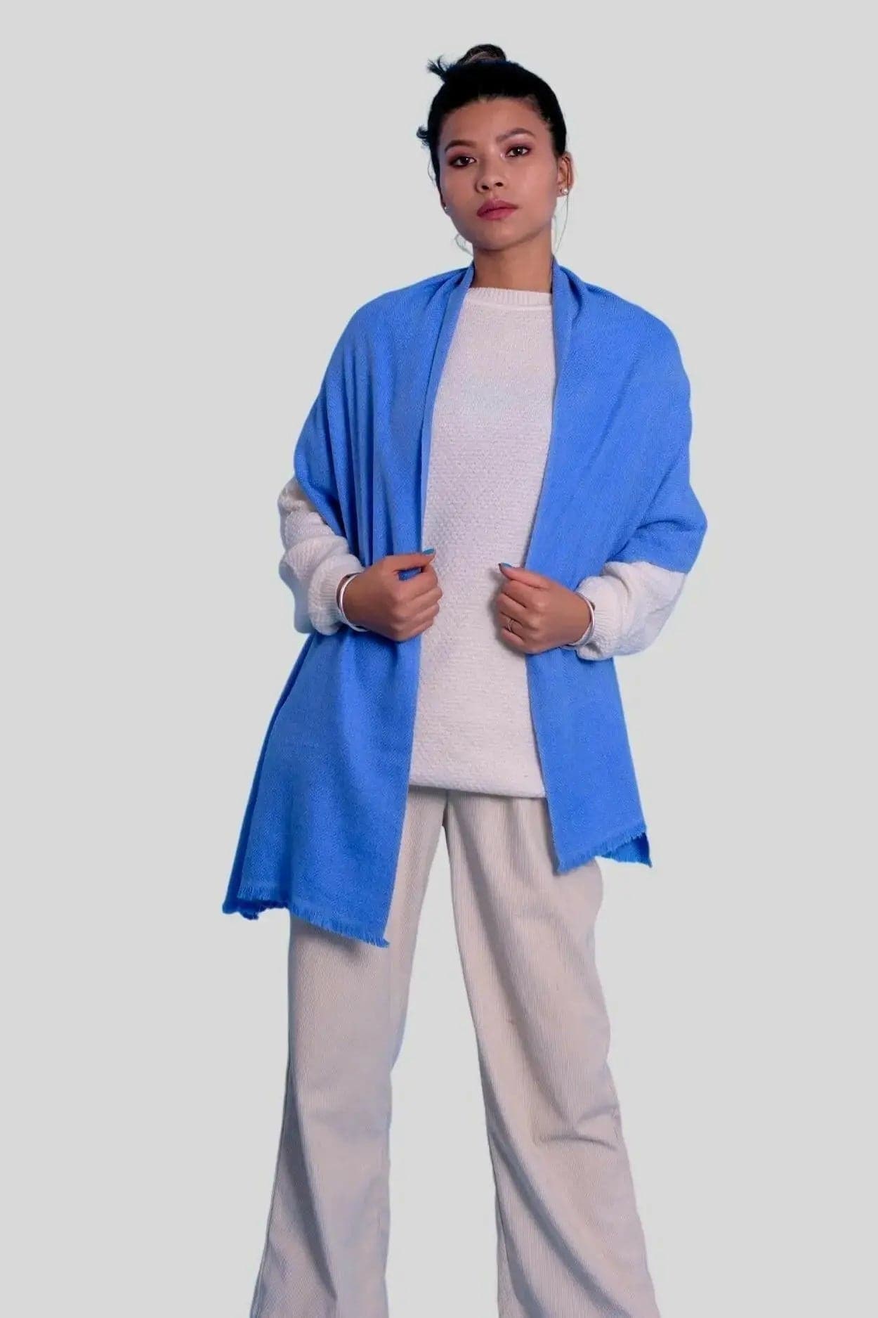 Woman in blue jacket and white pants wearing luxurious cashmere herringbone scarf