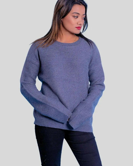 A woman in a blue sweater and black jeans showcasing the luxurious Cashmere Ribbed Pullover