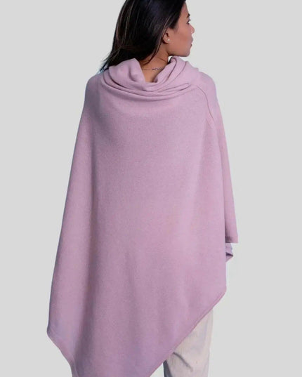 Woman wearing a pink cashmere turtle neck poncho with a cow neck