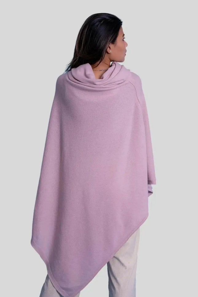 Woman wearing a pink cashmere turtle neck poncho with a cow neck