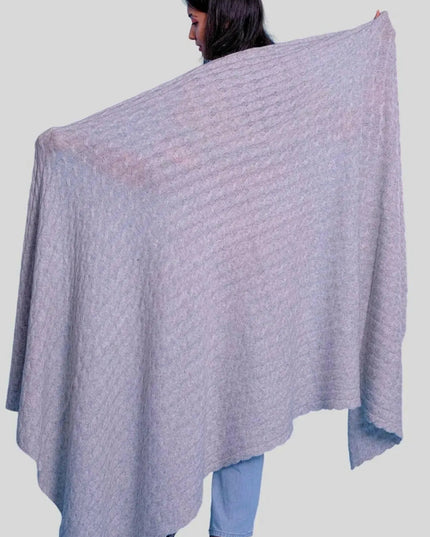 Woman wearing elegant grey poncho shawl from luxurious Italian Cashmere Cable Throw