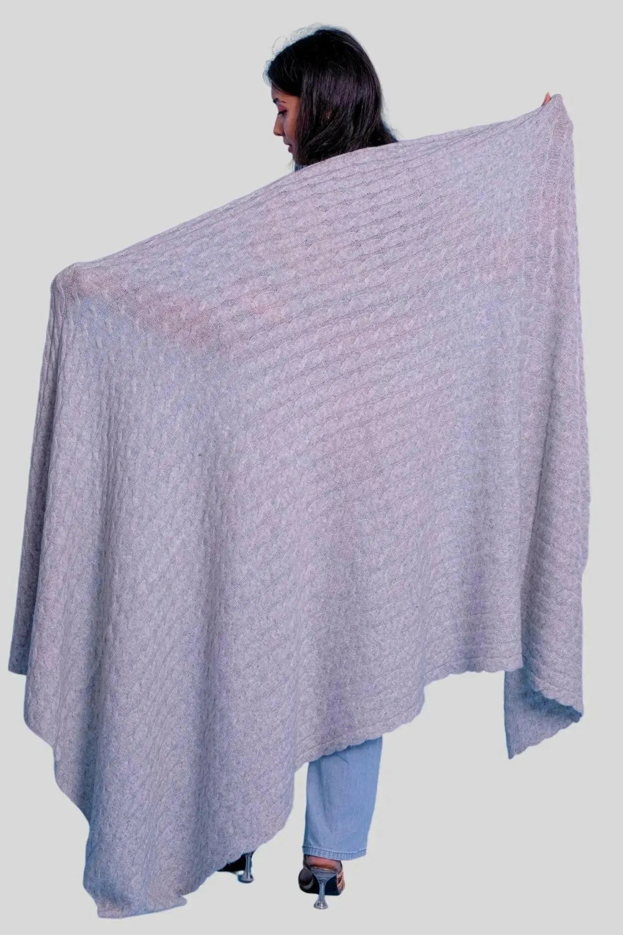 Woman wearing elegant grey poncho shawl from luxurious Italian Cashmere Cable Throw