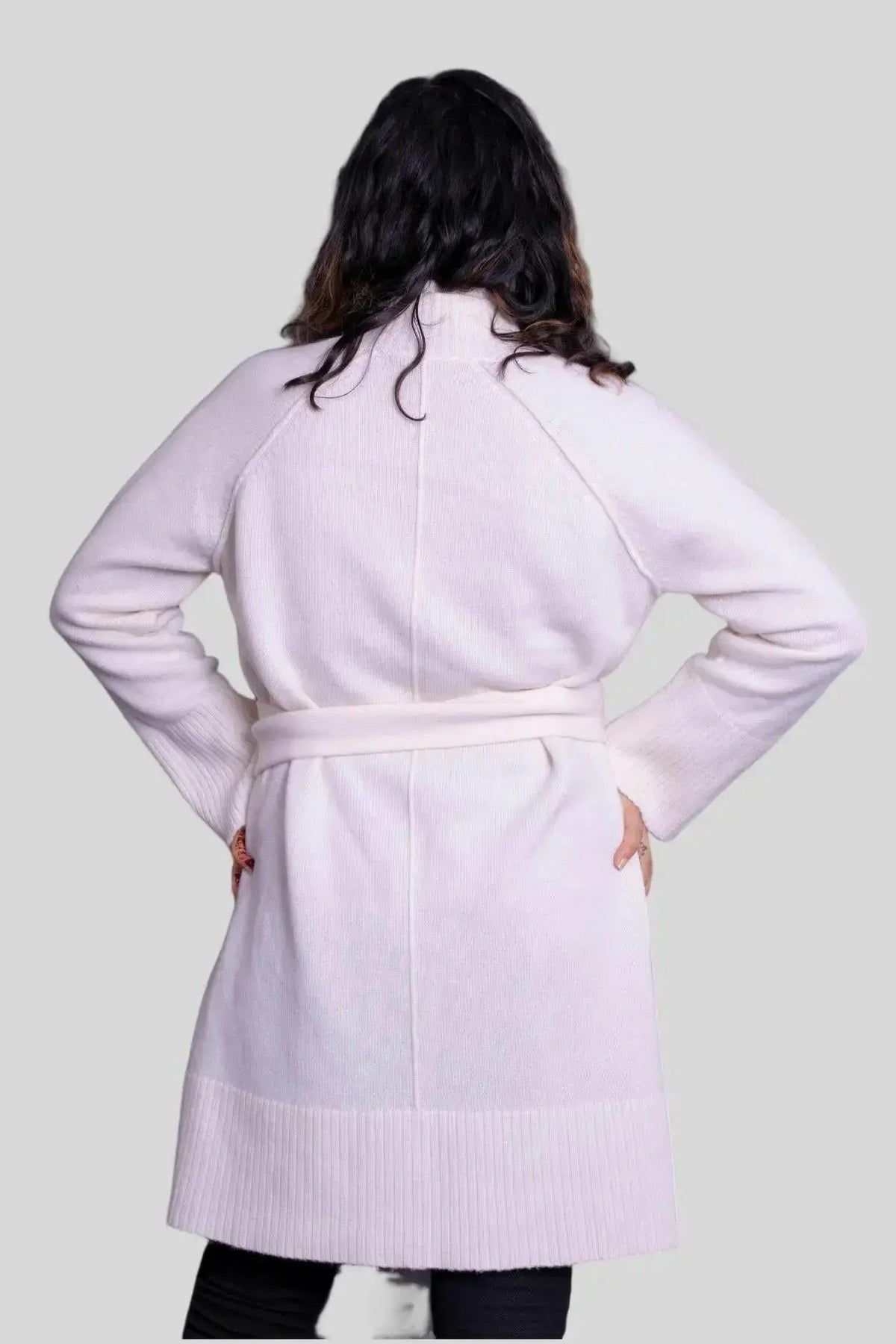 Woman wearing luxurious Italian cashmere robe in pink coat with white sweater
