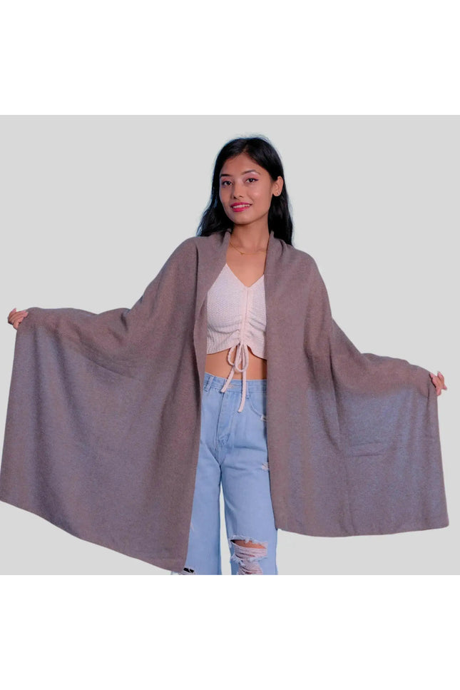 Woman in grey cape, white top, and blue jeans wearing Luxurious Italian Cashmere Scarf for winter wardrobe