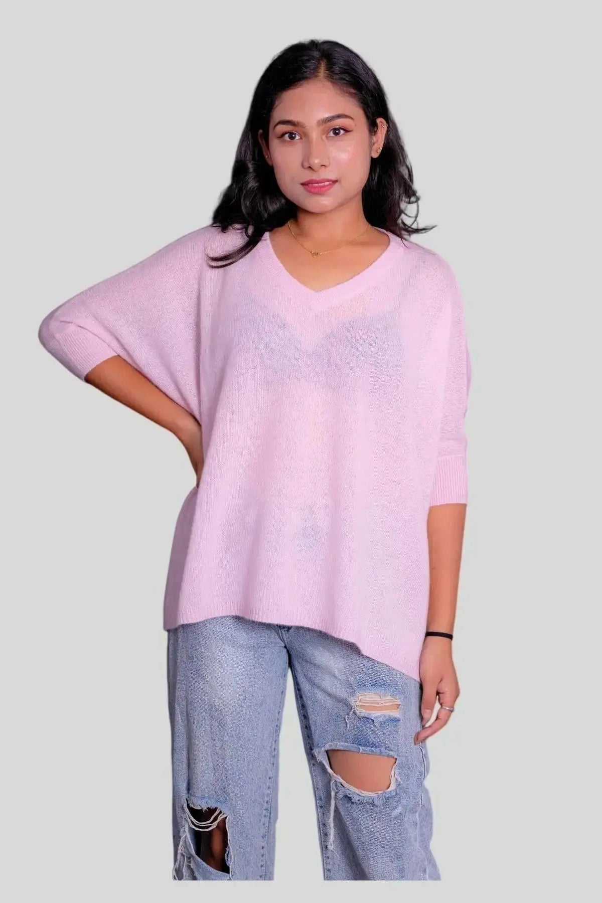 Luxurious Italian cashmere scarf on woman in pink sweater and ripped jeans