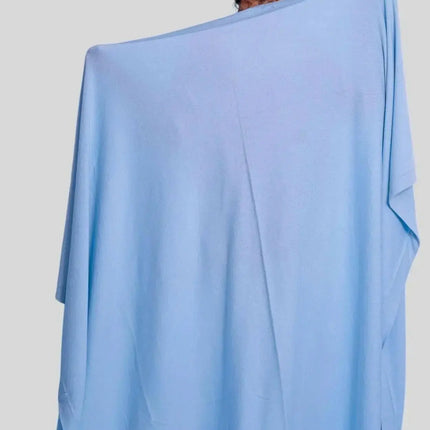 Woman wearing blue poncho with luxurious Italian cashmere throw blanket