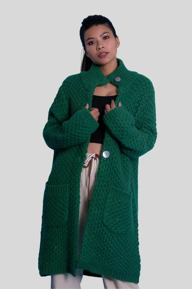 a woman in a green coat holding a cell phone 